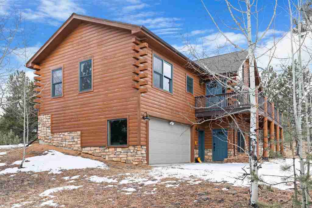Cabin exterior with the attached garage and driveway
