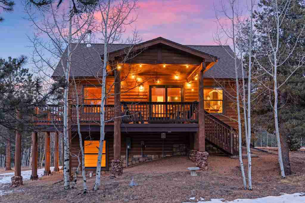 The covered deck at Rosalie Ridge Cabin lit up at twilight
