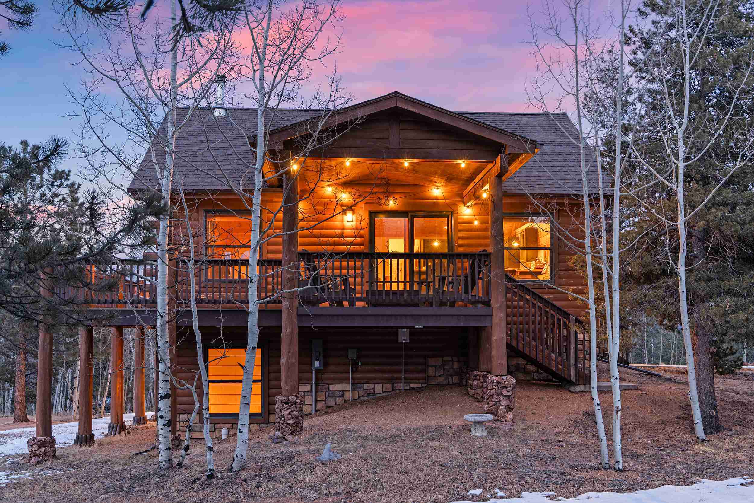 The covered deck at Rosalie Ridge Cabin lit up at twilight