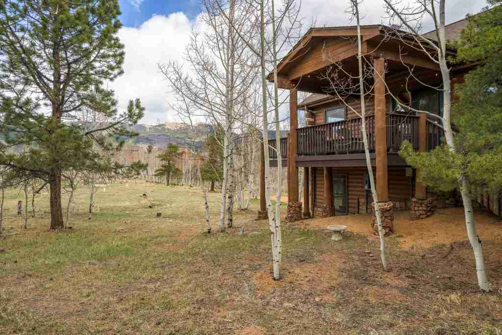 The wraparound deck at Rosalie Ridge Cabin above the backyard, framed by aspens