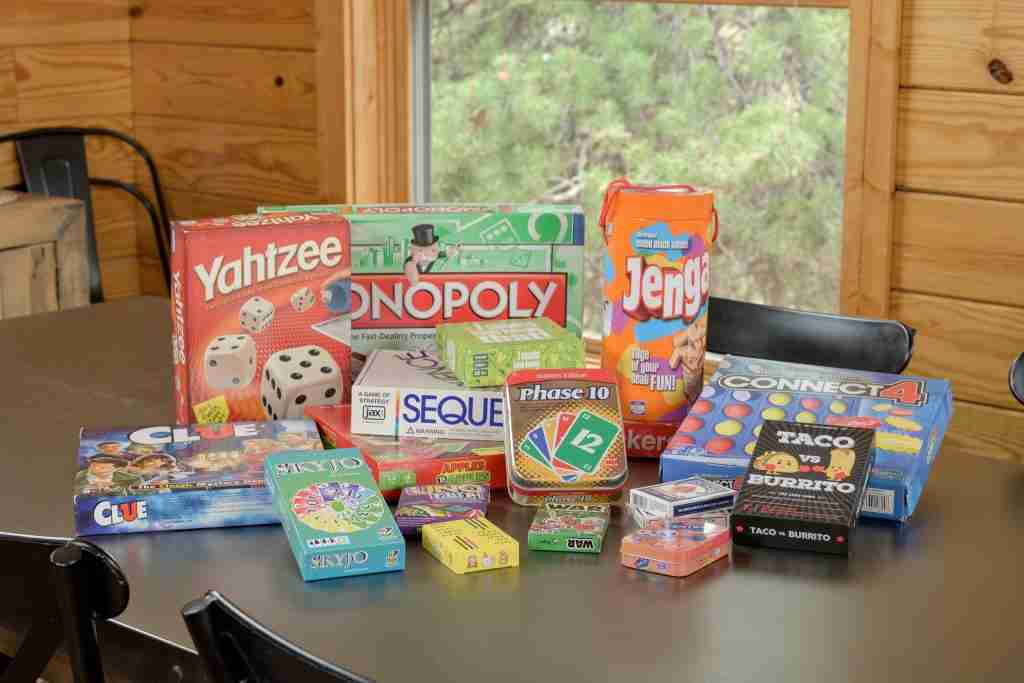 Stack of board games, including Yahtzee and Monopoly, on the dining table
