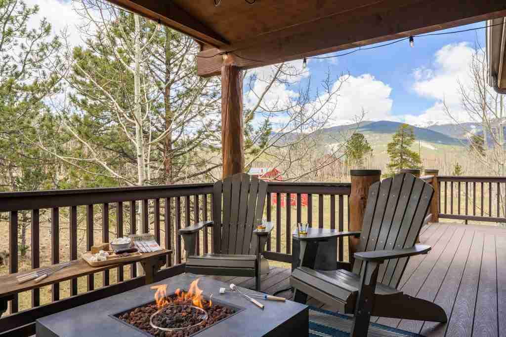 Gas fire table and Adirondack chairs on the covered deck, with mountain views