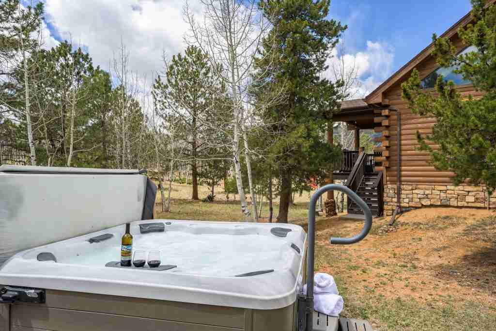 Hot tub with drinks and towels, steps from the cabin