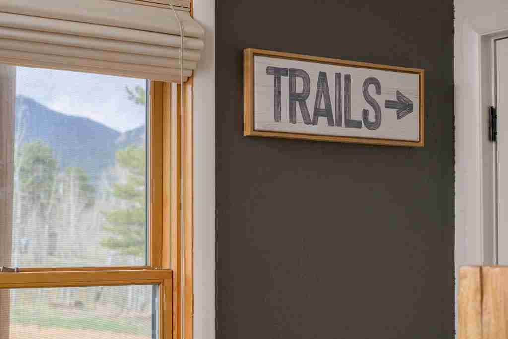 A rustic Trails sign beside a window in the entry lounge
