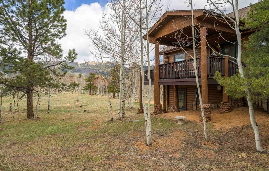 The wraparound deck at Rosalie Ridge Cabin above the backyard, framed by aspens