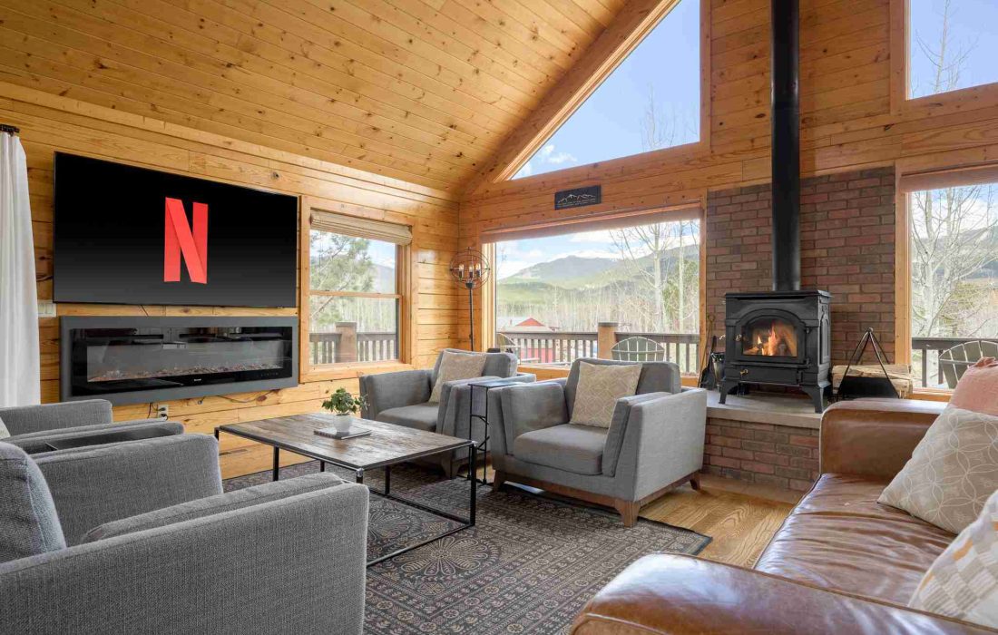 Smart TV above the electric fireplace in the great room, beside the wood stove