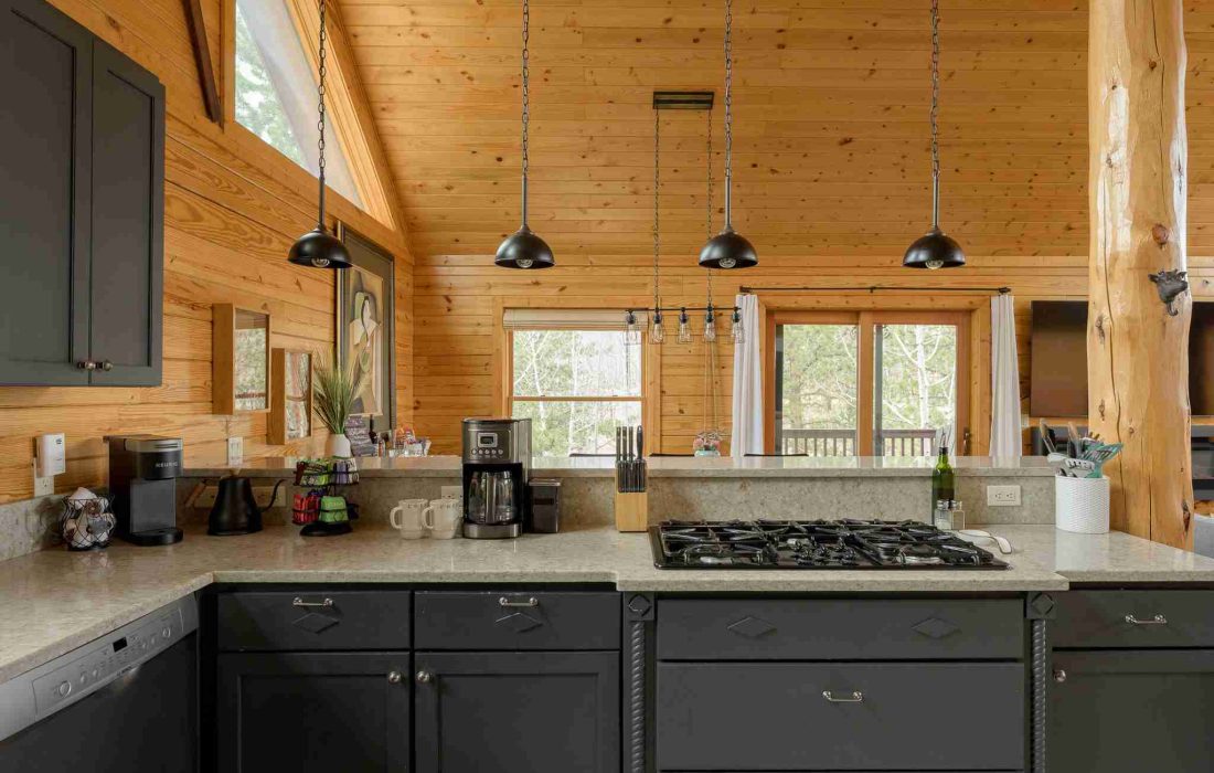 Kitchen with a gas cooktop and pendant lights beneath vaulted windows
