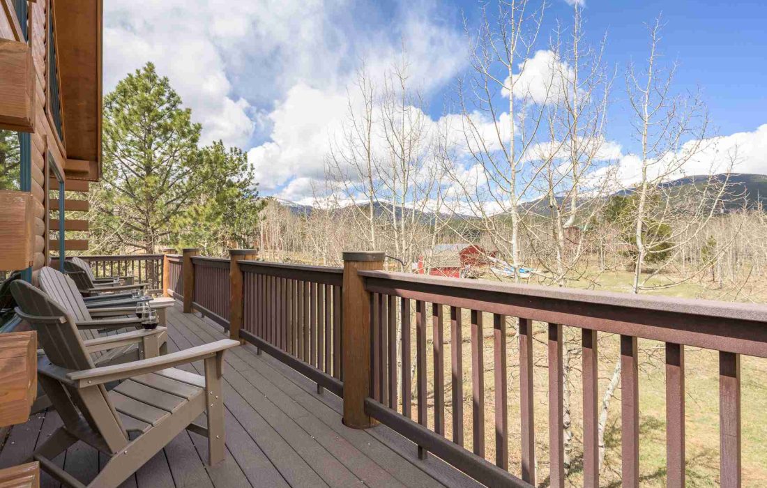 Wraparound deck with Adirondack chairs and views of the mountains