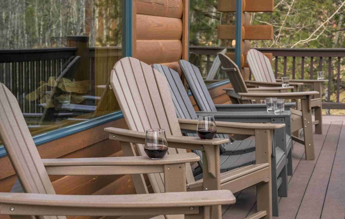 Row of Adirondack chairs on the covered wraparound deck