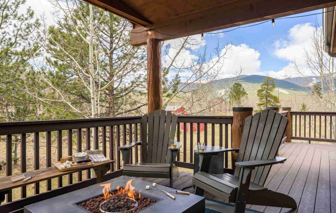Gas fire table and Adirondack chairs on the covered deck, with mountain views