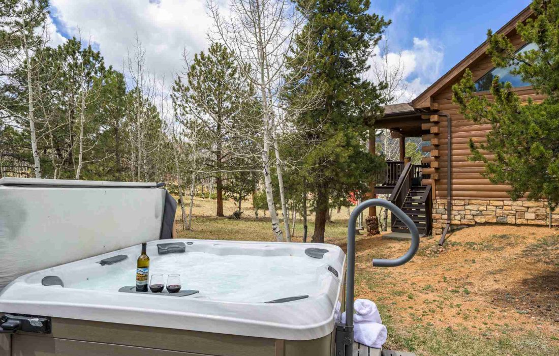 Hot tub with drinks and towels, steps from the cabin