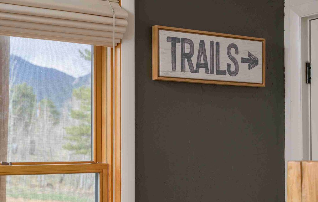 A rustic Trails sign beside a window in the entry lounge